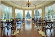 View from the back of an indoor wedding set up in front of large window