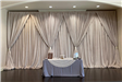 Dessert table in front of draped curtains