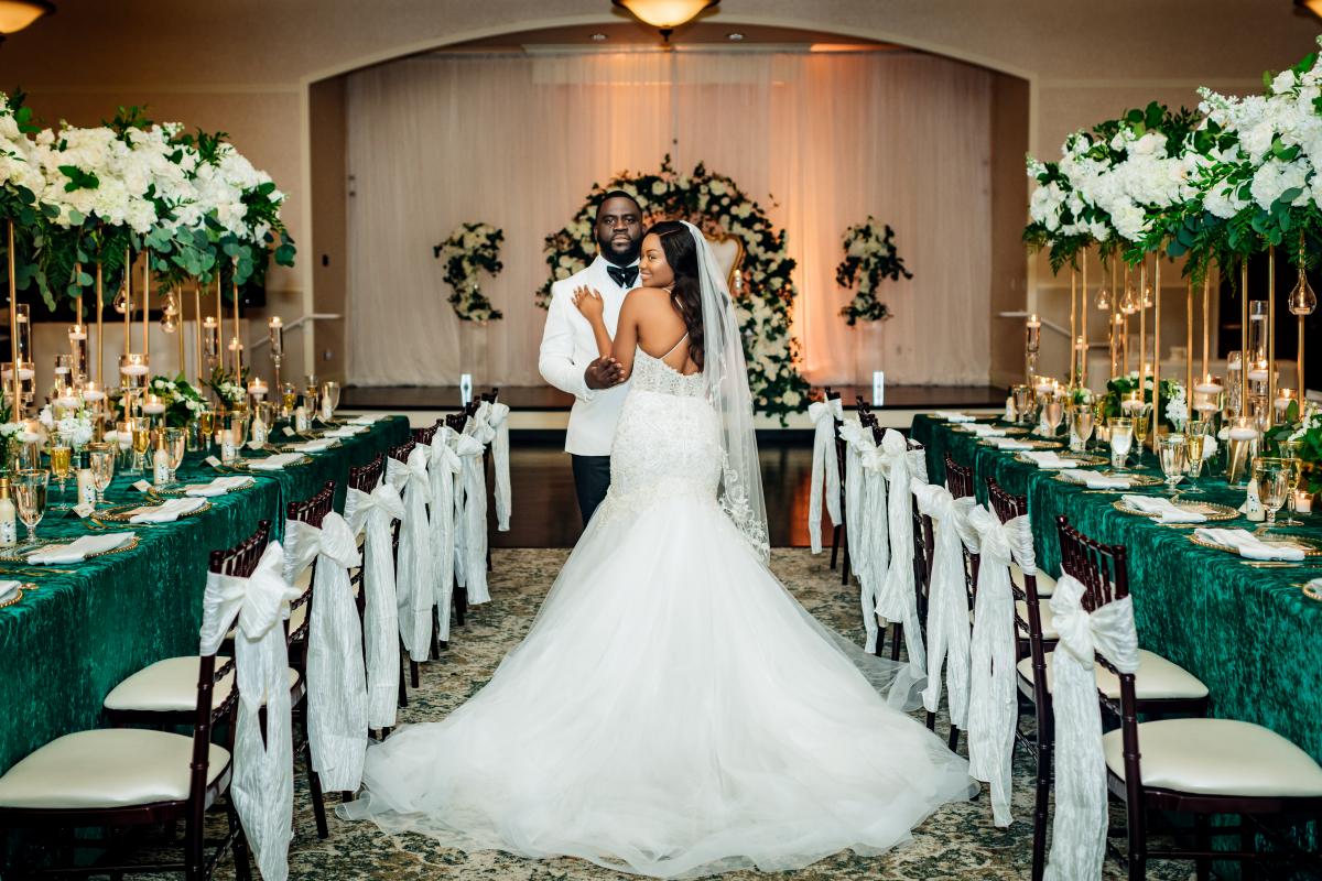Bride and groom in between two long tables